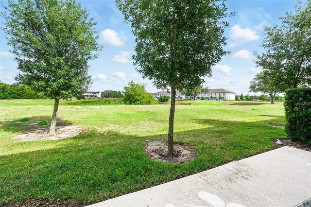 a view of a patio with a table chairs and a small yard