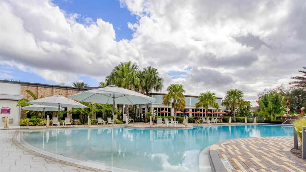 1421 Discovery Street Davenport, FL 33896 - Photo 39 of 44 a view of a lake with a table and chairs under an umbrella