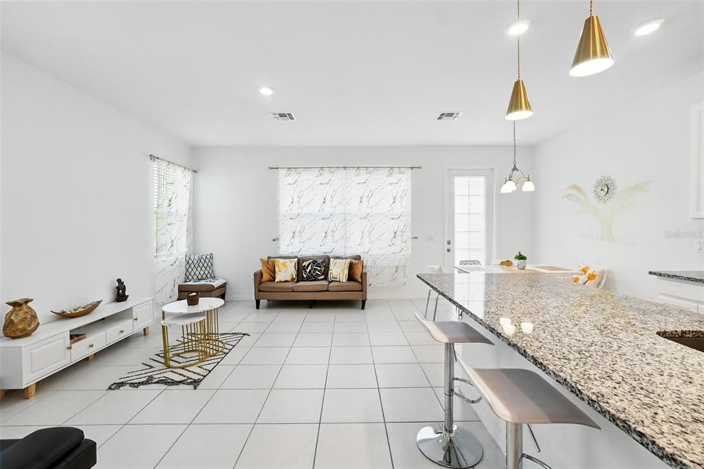 1421 Discovery Street Davenport, FL 33896 - Photo 6 of 44 a living room with furniture and a chandelier