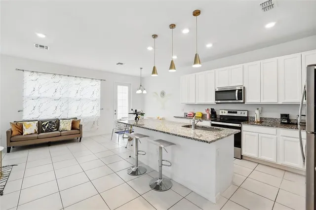 a kitchen with granite countertop a refrigerator and a stove top oven