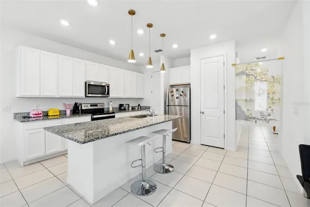 a kitchen with stainless steel appliances granite countertop a sink stove and cabinets