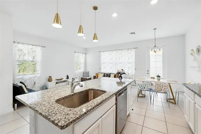 a kitchen with stainless steel appliances granite countertop a sink refrigerator and cabinets