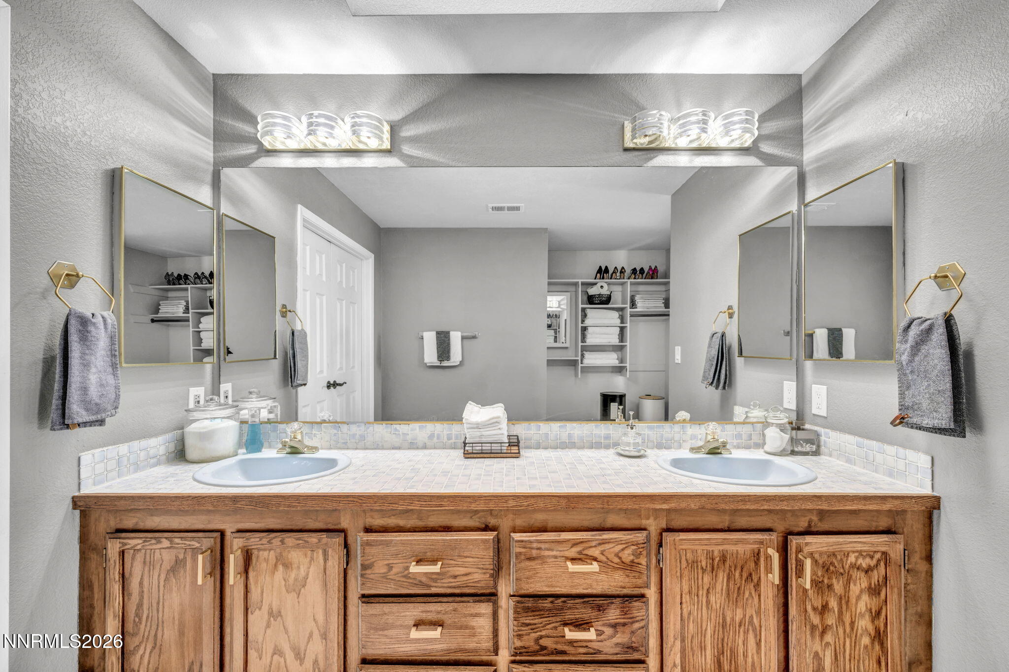 3332 Skyline View Drive Reno, NV 89509 - Photo 34 of 48 a bathroom with double vanity sinks a vanity a lamp and a mirror
