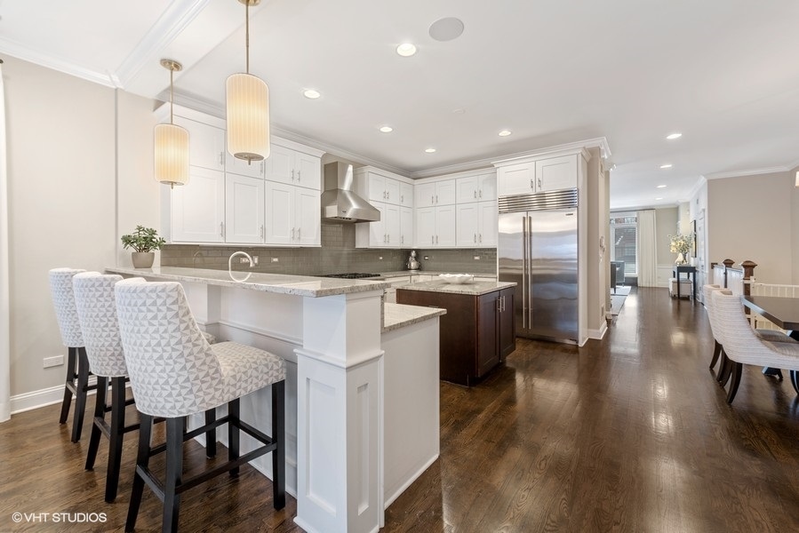 1248 West Grace Street, Unit 1 Chicago, IL 60613 - Photo 17 of 35 a kitchen with stainless steel appliances granite countertop table chairs sink and cabinets