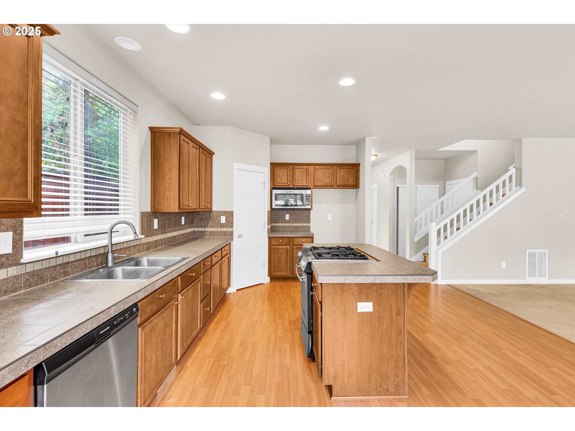 1892 Southwest Willowview Terrace Beaverton, OR 97003 - Photo 18 of 48 a kitchen with stainless steel appliances granite countertop a sink a stove and a wooden floors