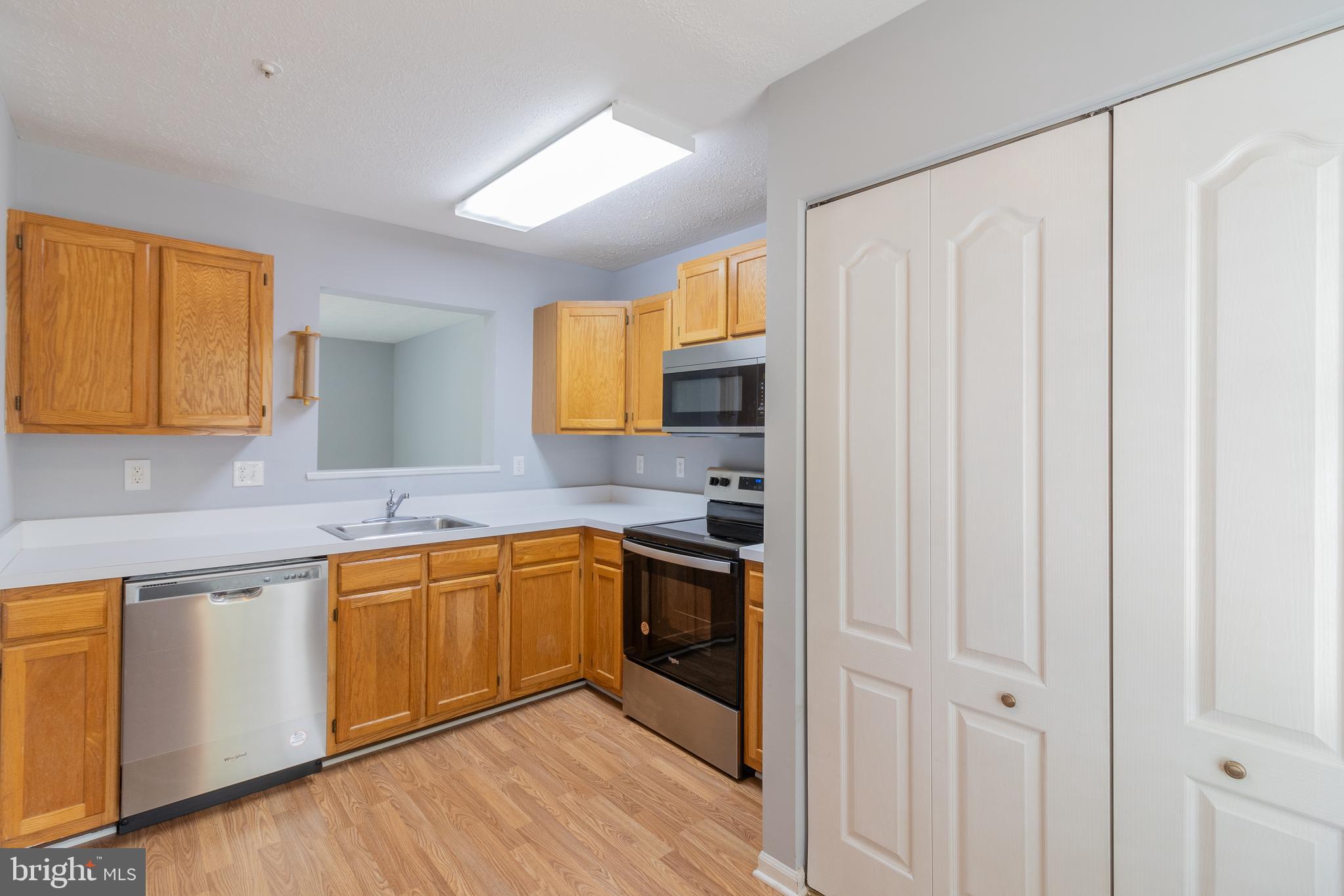 45292 Rumsford Lane California, MD 20619 - Photo 6 of 18 a kitchen with stainless steel appliances granite countertop a sink and cabinets with wooden floor
