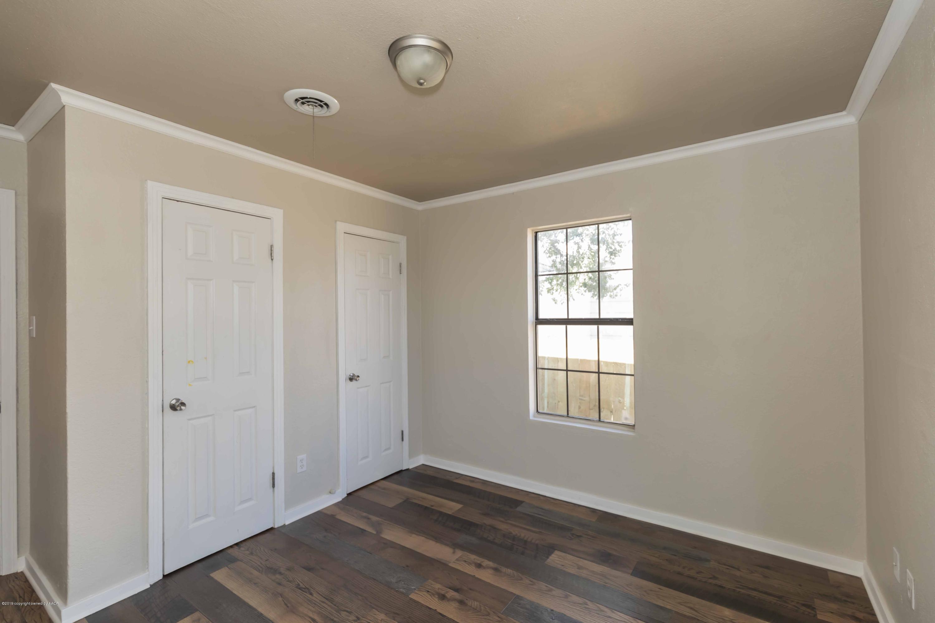1603 Southwest 48th Avenue Amarillo, TX 79110 - Photo 14 of 31 an empty room with wooden floor and windows