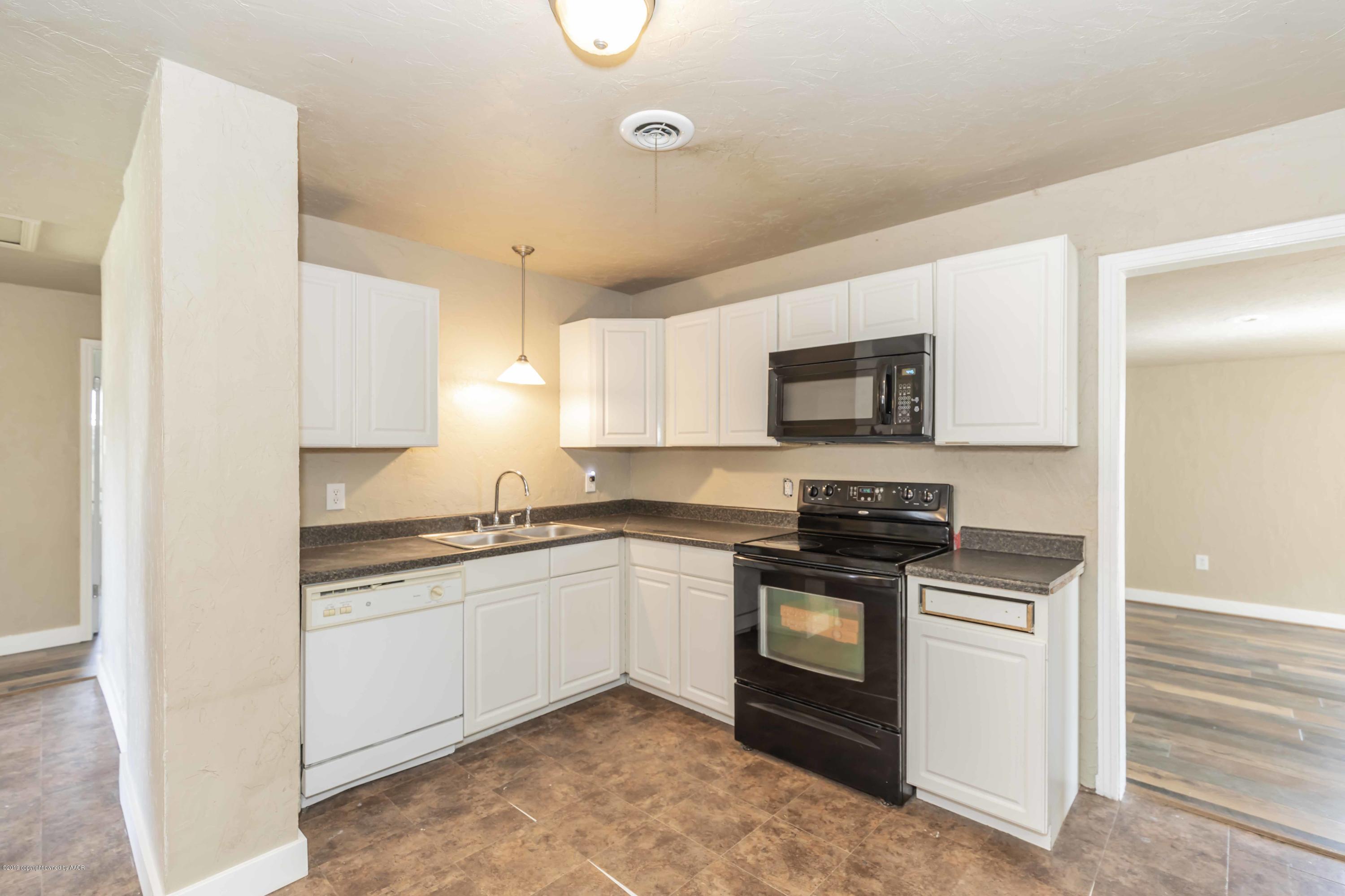 1603 Southwest 48th Avenue Amarillo, TX 79110 - Photo 4 of 31 a kitchen with stainless steel appliances granite countertop a stove and a sink