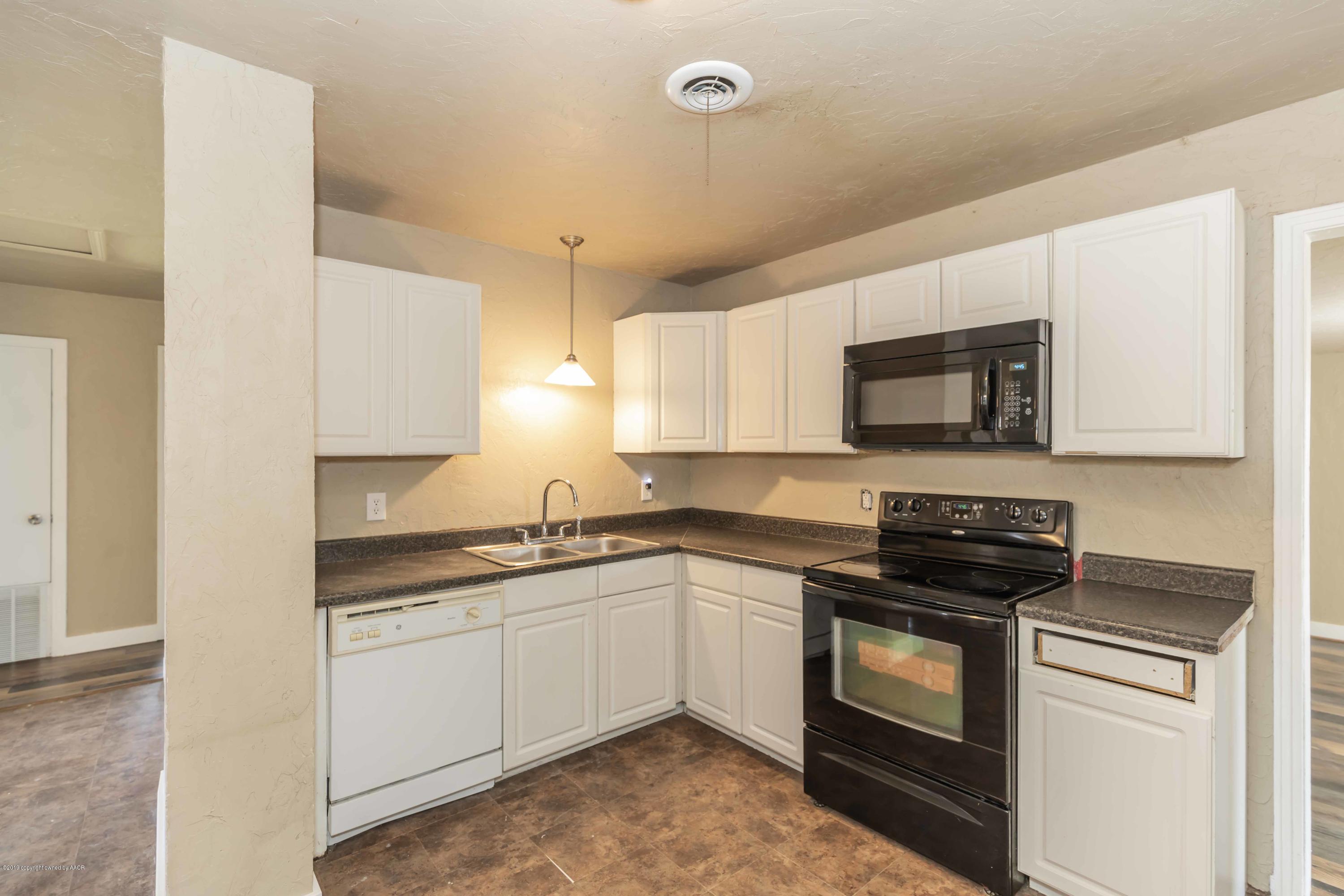 1603 Southwest 48th Avenue Amarillo, TX 79110 - Photo 7 of 31 a kitchen with a sink stove and microwave