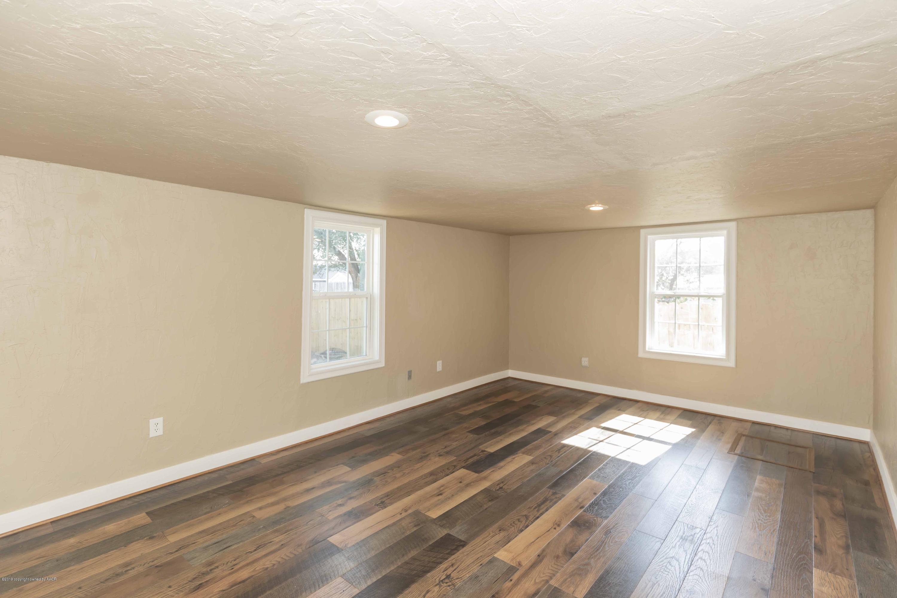 1603 Southwest 48th Avenue Amarillo, TX 79110 - Photo 8 of 31 a view of an empty room with wooden floor and a window
