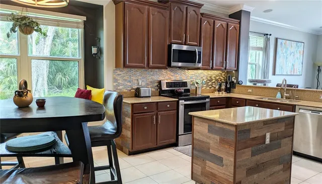 a kitchen with stainless steel appliances granite countertop a sink stove and microwave