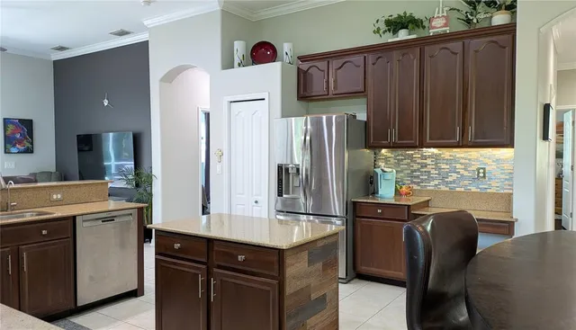 a kitchen with stainless steel appliances granite countertop a refrigerator and a stove top oven