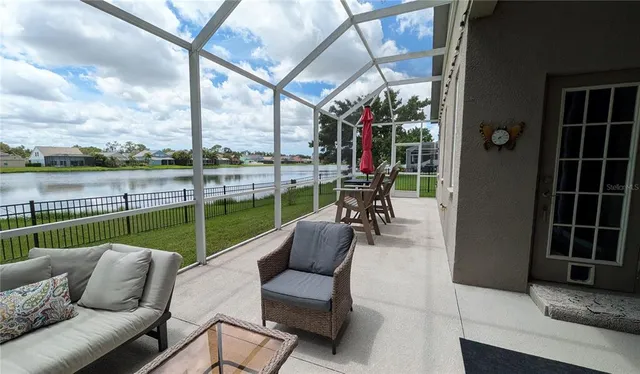 a swimming pool with outdoor seating and a garden