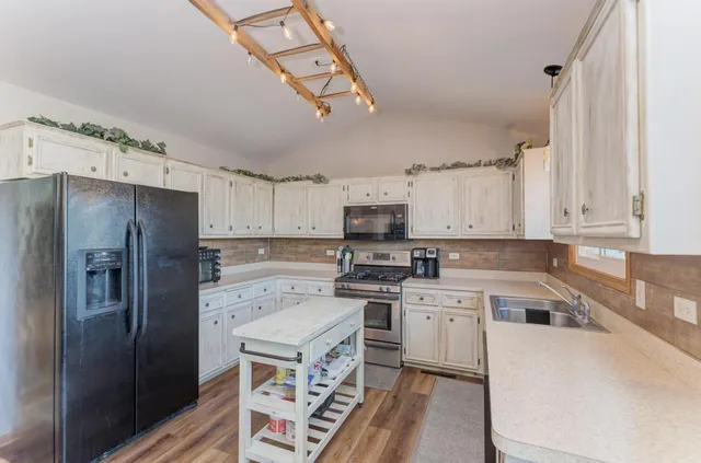 a kitchen with a refrigerator a sink and cabinets