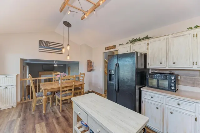 a kitchen with a table chairs refrigerator and cabinets