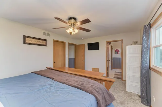 a bedroom with a large bed and a chandelier