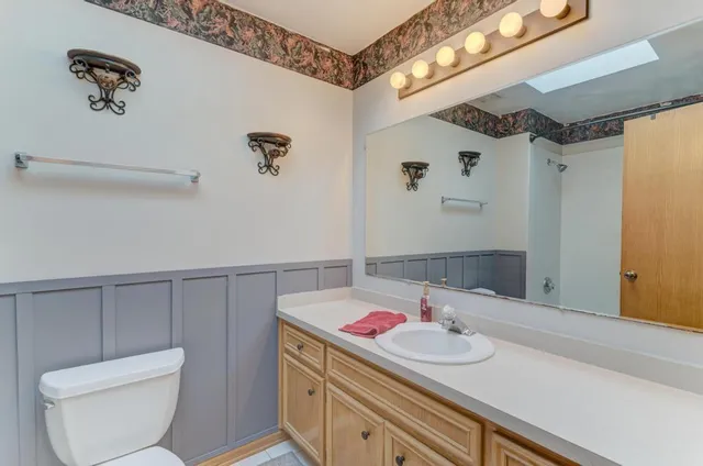 a bathroom with a sink a toilet and shower curtain