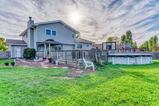 a view of a chair and table in backyard of the house