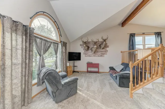a living room with furniture a fireplace and a large window
