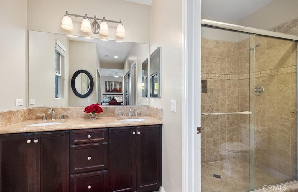 24 Colonial Way Aliso Viejo, CA 92656 - Photo 7 of 27 a bathroom with a granite countertop sink a large mirror and a shower