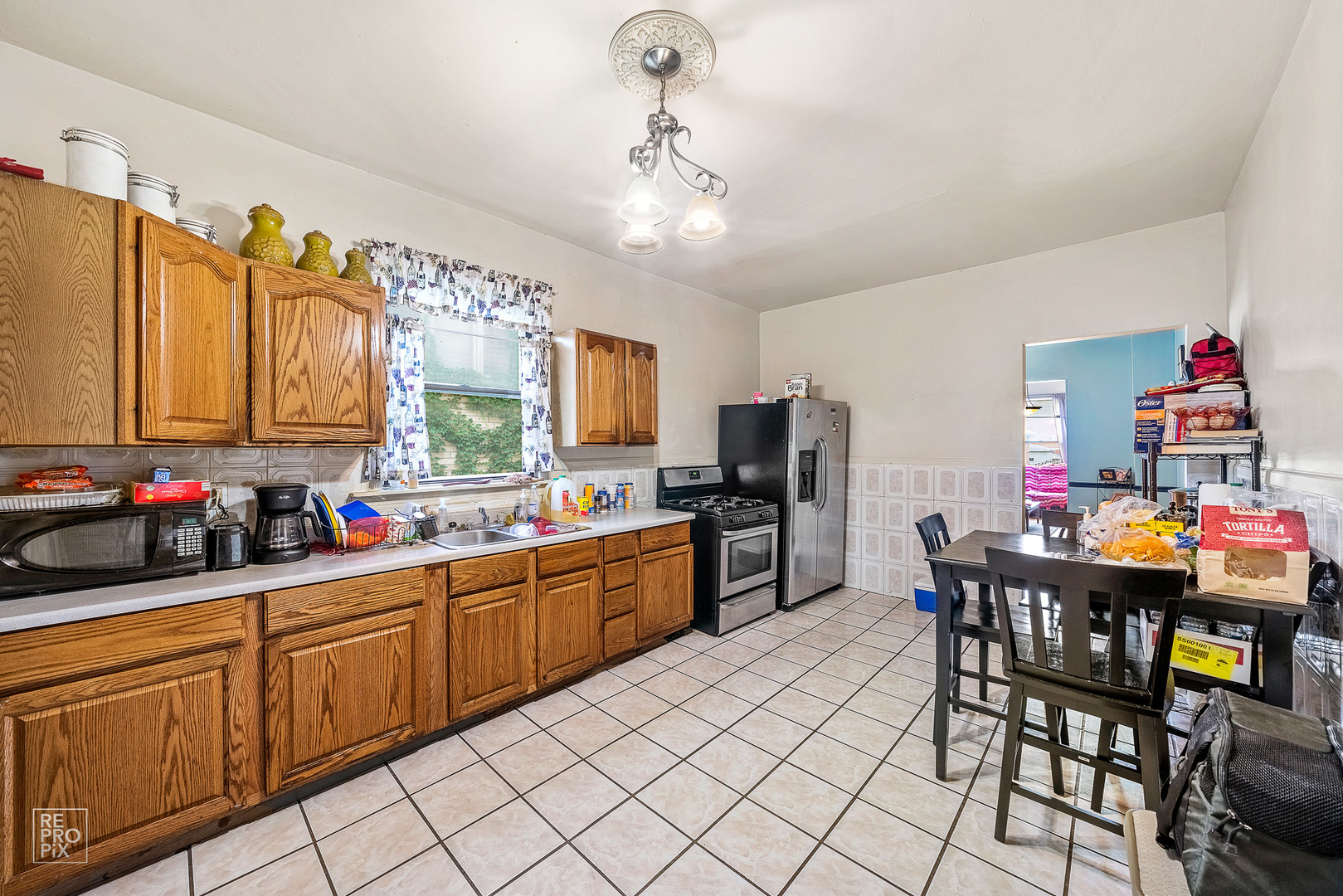 3101 Grove Avenue Berwyn, IL 60402 - Photo 4 of 14 a kitchen with stainless steel appliances granite countertop a sink dishwasher a dining table and chairs with wooden floor