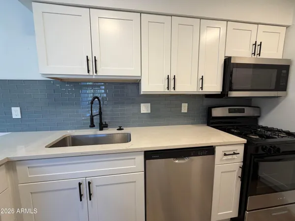 a kitchen with stainless steel appliances granite countertop a sink and a microwave