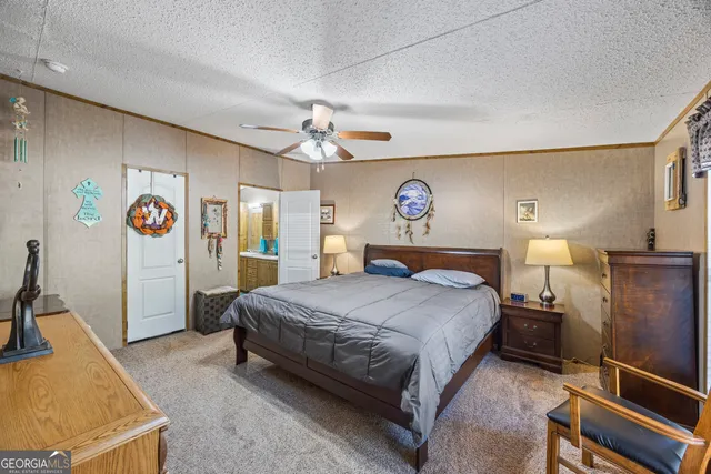 a bedroom with a bed and a flat tv screen on dresser