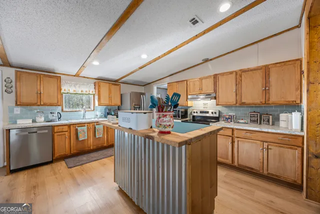 a kitchen with stainless steel appliances granite countertop a sink and cabinets