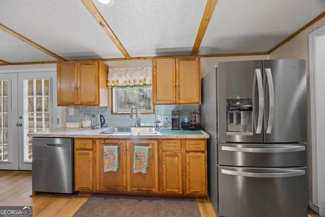a kitchen with stainless steel appliances granite countertop a refrigerator and a sink
