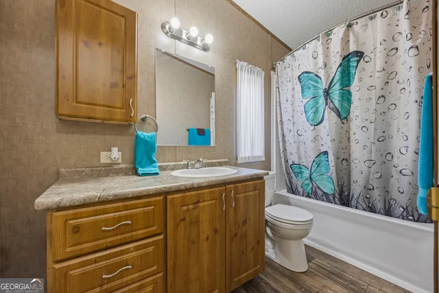 a bathroom with a granite countertop toilet sink and mirror