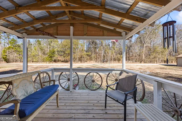 a patio with wooden floor a yard a table and chairs