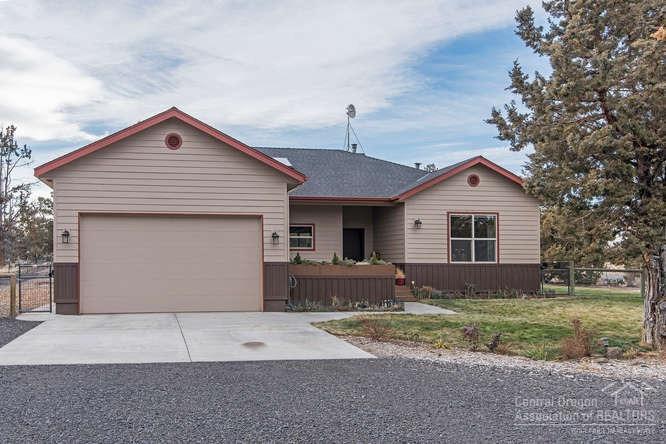 23095 Alfalfa Market Road Bend, OR 97701 - Photo 1 of 25 a front view of a house with a yard and garage