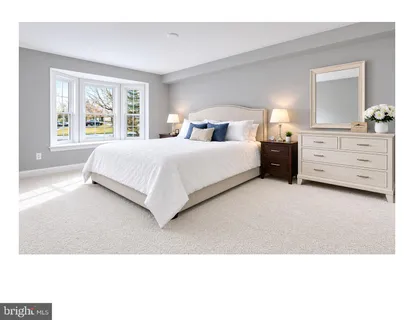 a bedroom with a bed and a large mirror