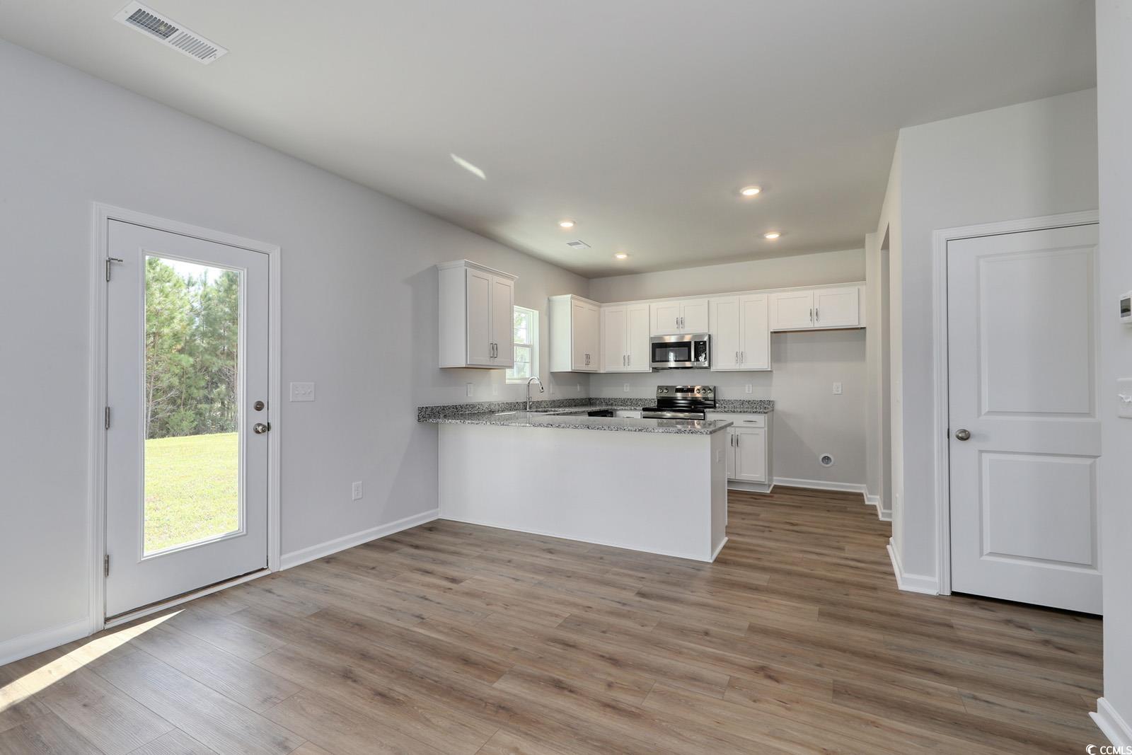 3416 Logan Street Conway, SC 29526 - Photo 8 of 30 Kitchen with white cabinetry, recessed lighting, light wood finished floors, light stone countertops, and a peninsula