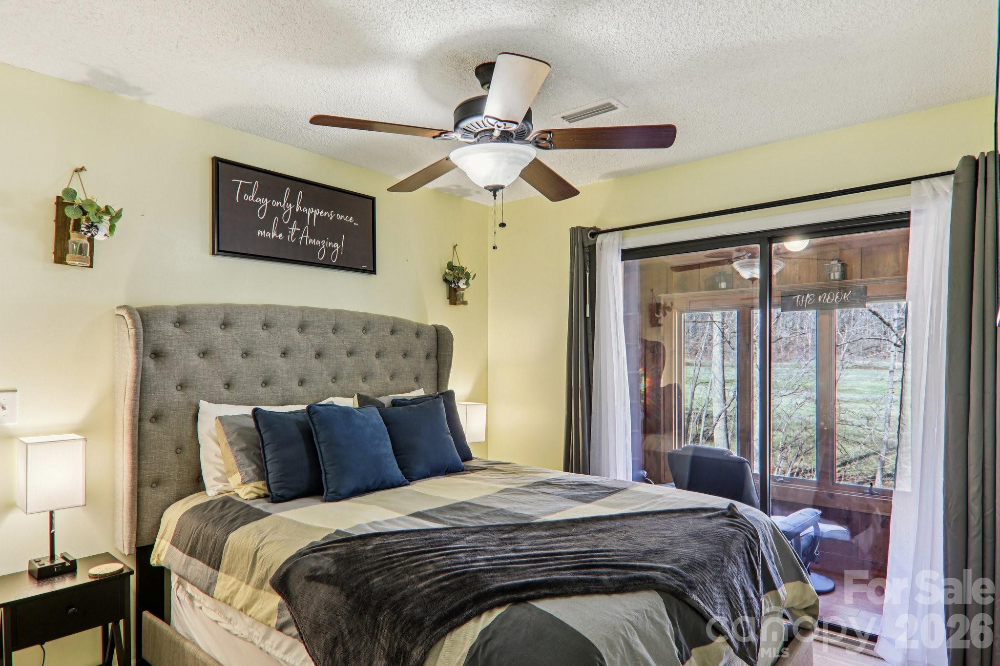 129 Riverside Villa Drive Maggie Valley, NC 28751 - Photo 23 of 43 a bedroom with a bed and a chandelier