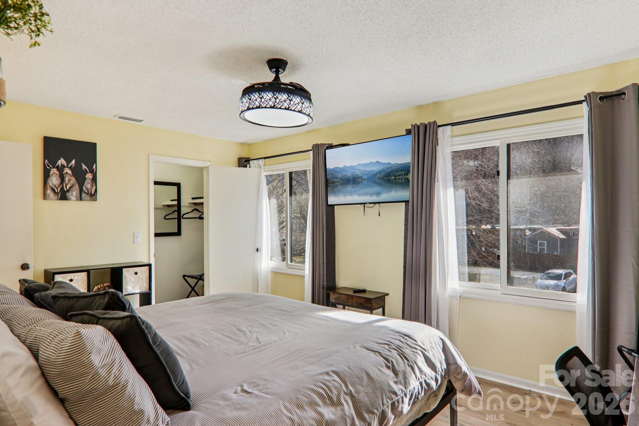 129 Riverside Villa Drive Maggie Valley, NC 28751 - Photo 27 of 43 a bedroom with a bed and a chandelier