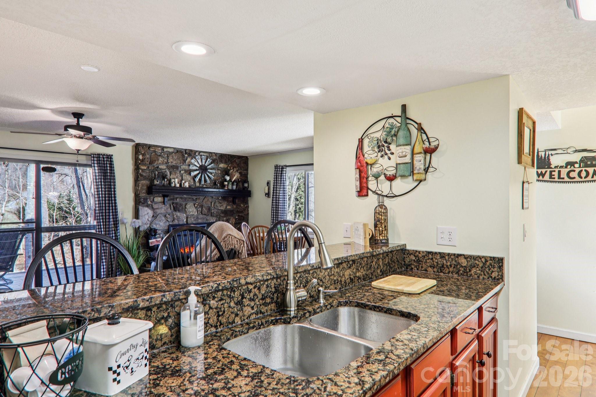 129 Riverside Villa Drive Maggie Valley, NC 28751 - Photo 29 of 43 a kitchen with a sink a stove and a dining table with wooden floor