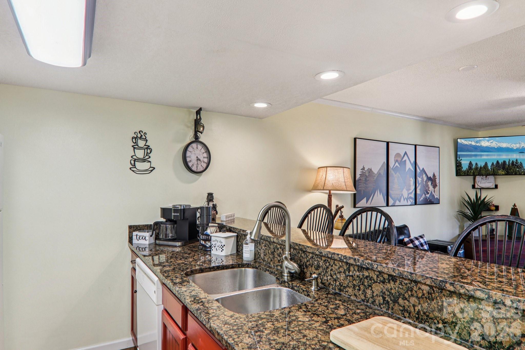 129 Riverside Villa Drive Maggie Valley, NC 28751 - Photo 30 of 43 a kitchen with kitchen island granite countertop a sink a granite counter tops and a view of living room