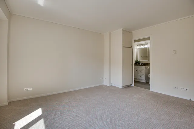 an empty room with closet and windows