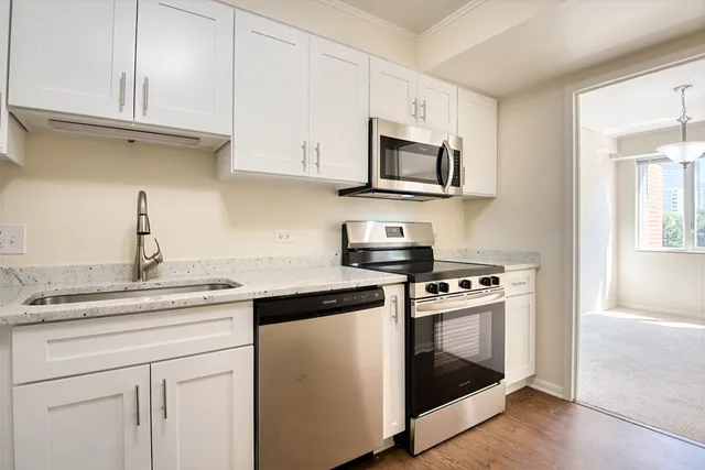 a kitchen with white cabinets and stainless steel appliances