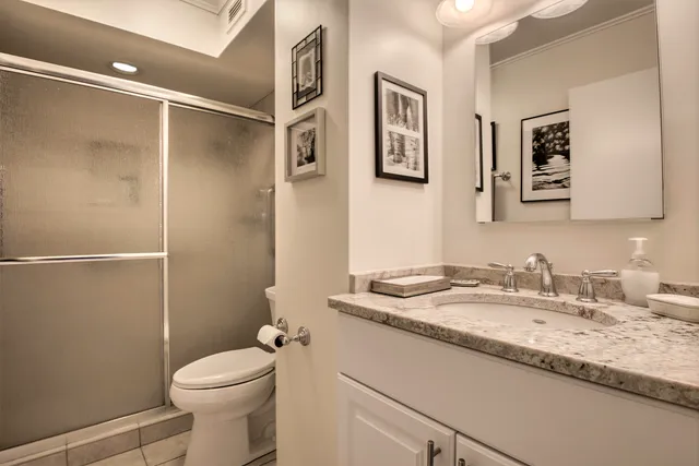 a bathroom with a granite countertop sink toilet and shower