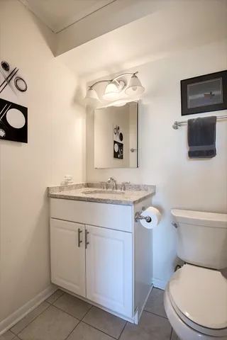 a bathroom with a granite countertop toilet sink and mirror