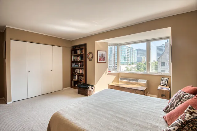 a bedroom with a bed and a large window