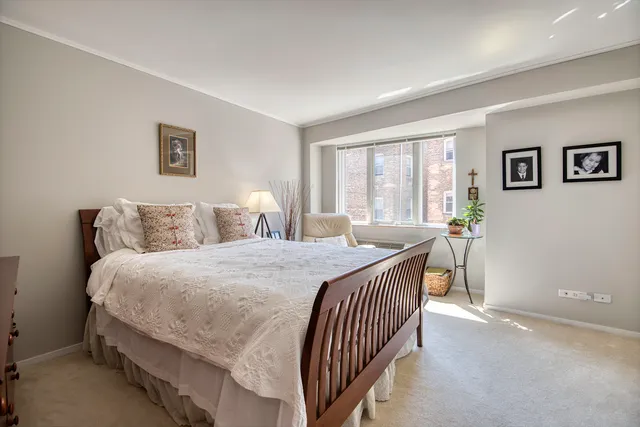 a bedroom with a bed and a large window