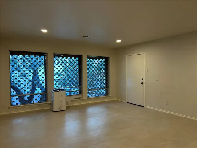 a view of a room with a window and chandelier fan