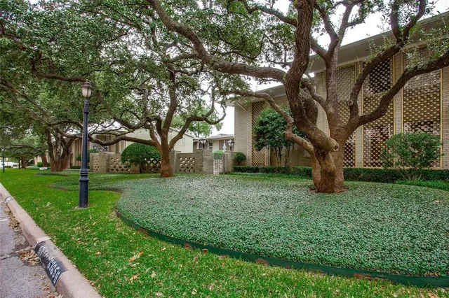 a front view of a house with a yard and fountain