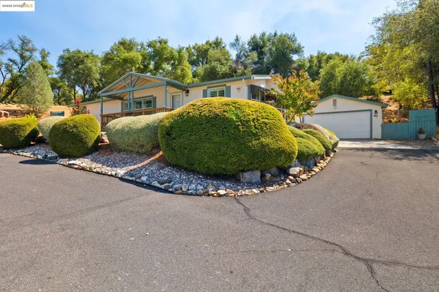 a view of a house with a street and trees