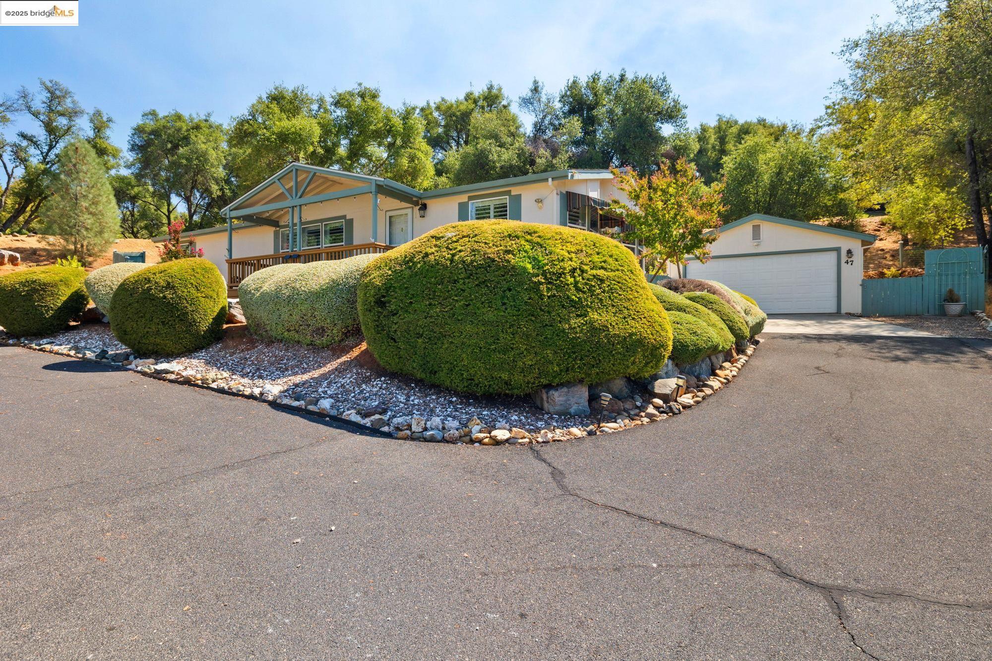 a view of a house with a street and trees