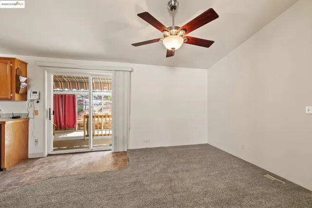 an empty room with fan and windows