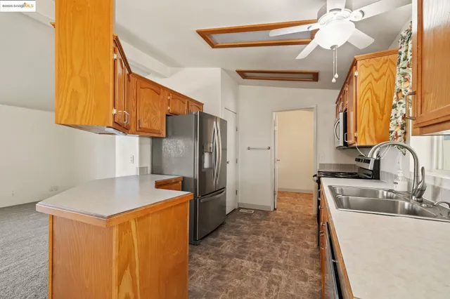a kitchen with stainless steel appliances granite countertop a sink refrigerator and cabinets